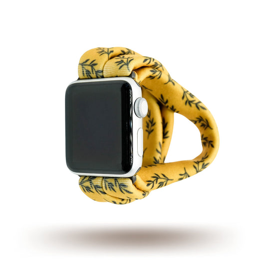 Golden Laurel Yoga Band® featuring a delicate black laurel leaf print on a vibrant goldenrod fabric. A breathable, stretchy watch strap with a patent-pending design compatible with Apple Watch, Fitbit, and Samsung Galaxy models.