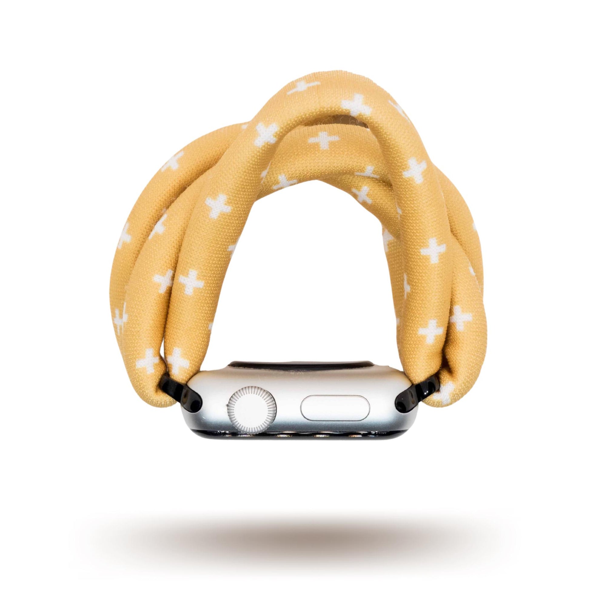 Golden Plus Yoga Band® featuring a white plus sign print on a golden-tan fabric background. A breathable, stretchy watch strap with a patent-pending design compatible with Apple Watch, Fitbit, and Samsung Galaxy models.