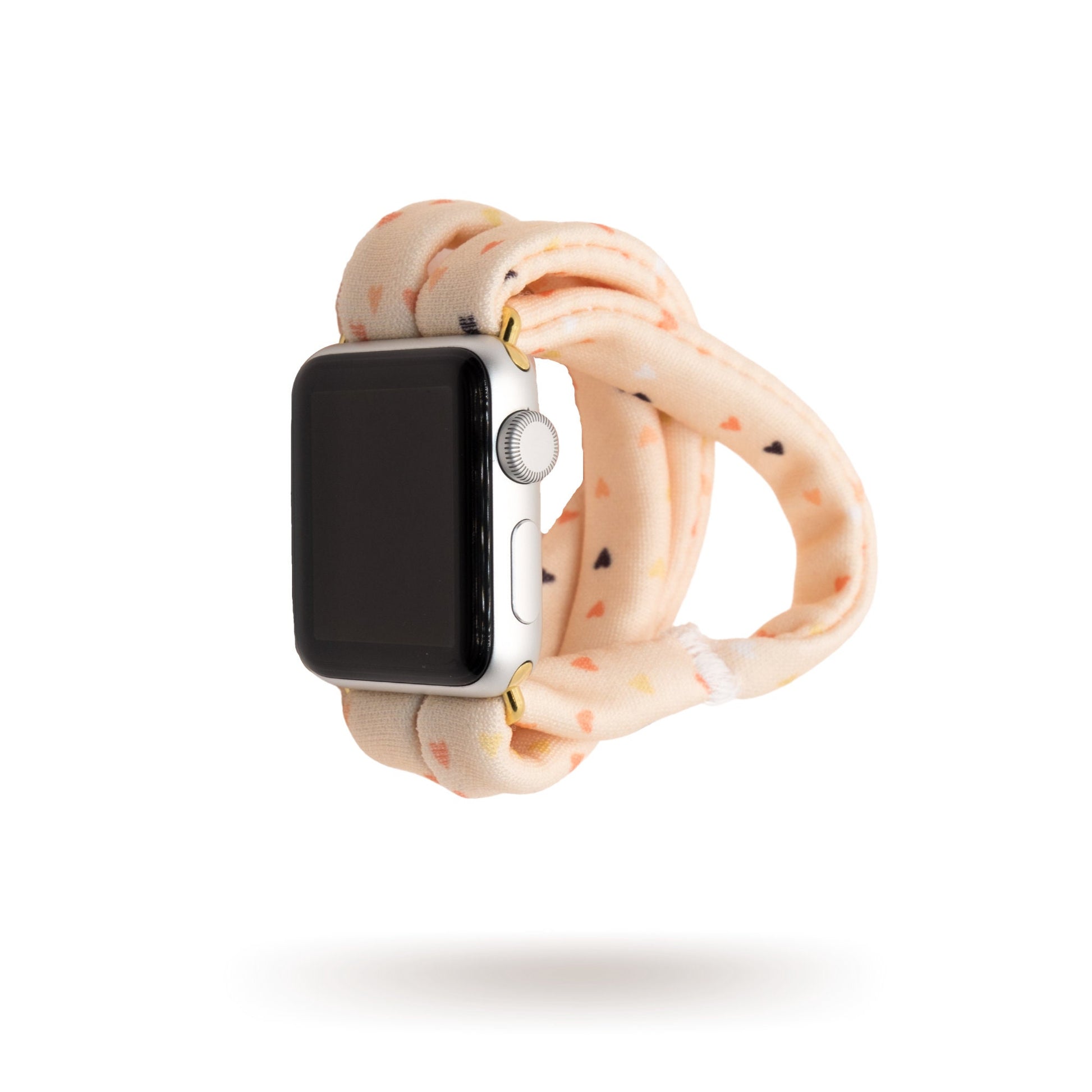 Heartbeat Yoga Band® featuring a tiny heart print in peach, cream, and pink tones. A breathable, stretchy fabric watch strap with a patent-pending design compatible with Apple Watch, Fitbit, and Samsung Galaxy models.