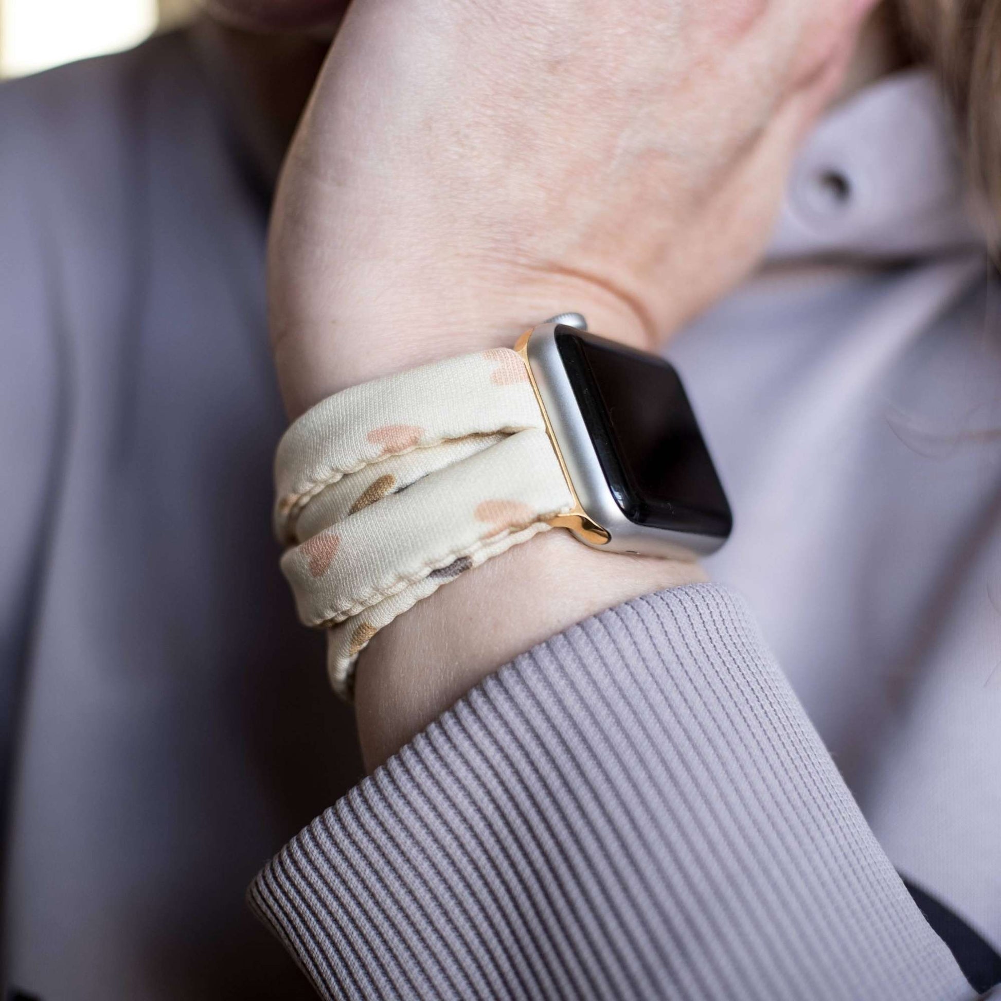 Heartbeat Yoga Band® featuring a tiny heart print in peach, cream, and pink tones. A breathable, stretchy fabric watch strap with a patent-pending design compatible with Apple Watch, Fitbit, and Samsung Galaxy models.